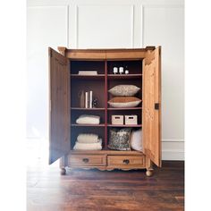 a wooden cabinet with towels and other items in it