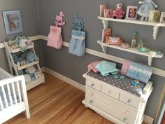 a baby's room is decorated in blue, pink and grey colors with teddy bears on the shelves