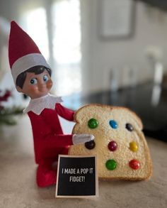 an elf is sitting next to a piece of bread