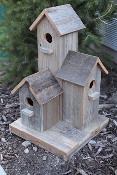 two wooden bird houses sitting in the dirt