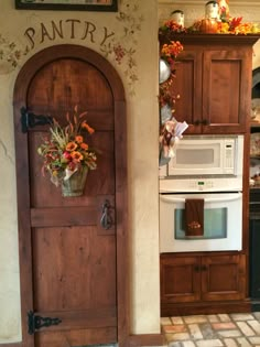 a white stove top oven sitting inside of a kitchen next to a wooden pantry door