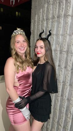 two women dressed in costumes posing for the camera