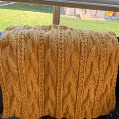 a yellow blanket sitting on top of a window sill