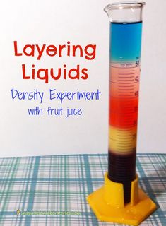 a beakle filled with liquid sitting on top of a table next to a sign that says layering liquids density experiment with fruit juice