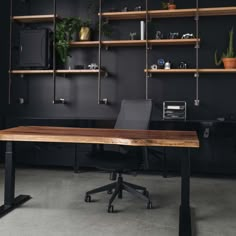 an office with black walls, shelves and a wooden desk in the middle is shown