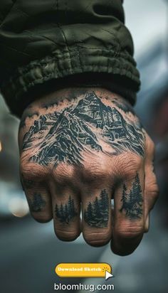 a man's hand with mountains and trees tattooed on the middle of his arm