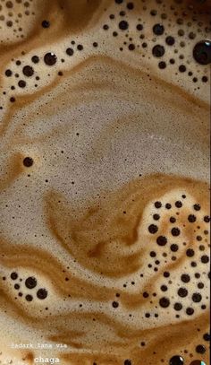 some brown and white liquid in a glass bowl with black dots on the bottom,