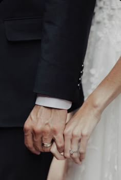 a close up of two people holding hands