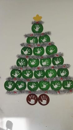 a christmas tree made out of green plates with handprints on the front and palm prints on the back