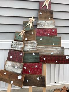 a christmas tree made out of pallets and wooden planks with stars on top