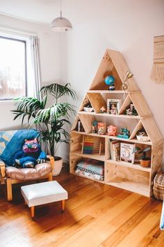 a living room filled with furniture and a wooden shelf next to a potted plant