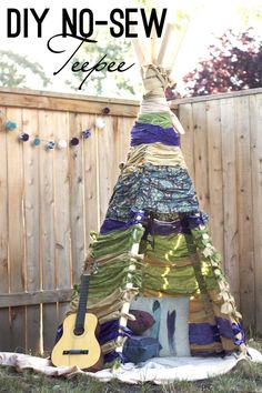 a teepee tent made out of fabric and yarn with the words diy no sew