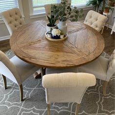 a dining room table with chairs around it and a potted plant in the center