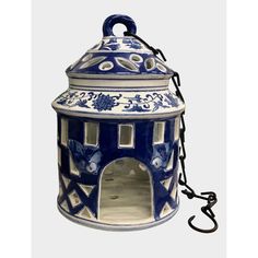 a blue and white ceramic lantern hanging from a chain