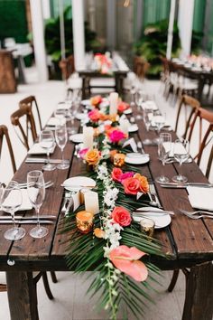 a long table with flowers and candles on it