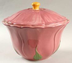 a pink glass covered dish with a yellow top