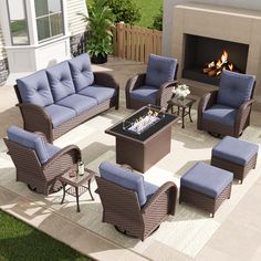 an outdoor living room with blue cushions and chairs around a fire place in the back yard