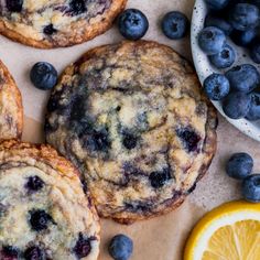 blueberry muffins and orange slices are on the table next to each other