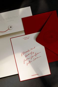 two red and white envelopes sitting next to each other on top of a table