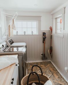 a laundry room with a washer, dryer and ironing board in it