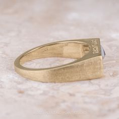 a yellow gold signet ring with a stone embedded in it