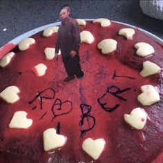 a cake that has been decorated with white hearts and a man standing in the middle