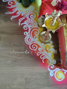 an arrangement of flowers and candles on a colorful table cloth in front of a mirror