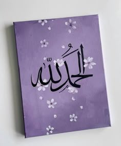 an arabic calligraphy is displayed on a purple background with white flowers and petals in the foreground