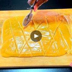 a person cutting cheese on top of a wooden board