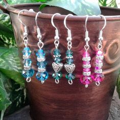 four pairs of earrings are hanging from a potted plant