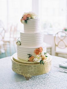 a white wedding cake with flowers on top