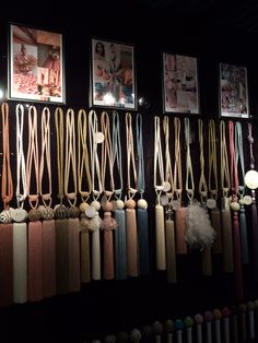 a bunch of different colored ties hanging on a wall in front of pictures and lights