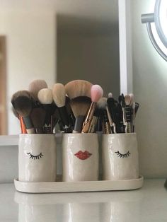 makeup brushes are arranged in a cup on the counter top, with eyelashes painted on it