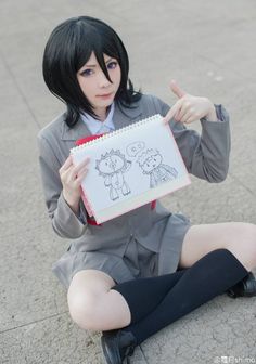 a person sitting on the ground holding a drawing