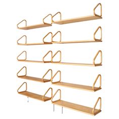 four wooden shelves with hooks on each side and one hanging from the wall, all in different shapes and sizes