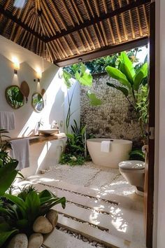 an outdoor bathroom with plants and rocks on the floor