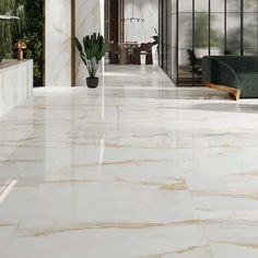 a large white marble floor with plants in the center and two couches on either side