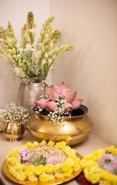 there are some flowers in the vases on the table next to plates with food