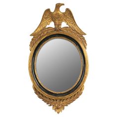 an ornately decorated gold framed mirror with two birds on the top and bottom part