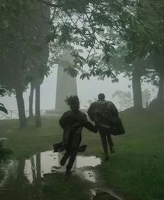 two people are walking in the rain with umbrellas