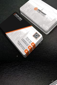 two business cards sitting on top of a black table with an orange and white design