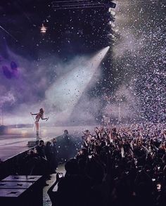 a woman standing on top of a stage surrounded by confetti