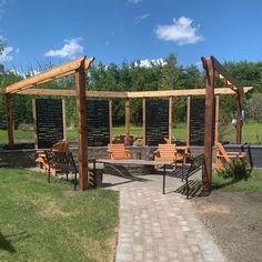 an outdoor seating area with wooden benches and pergolated areas on the side walk