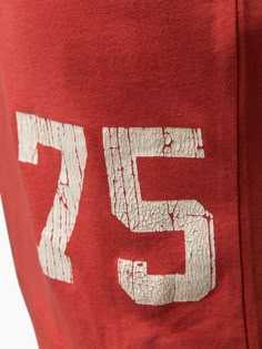 a red sweatshirt with white numbers on the front and back side that says'75 '