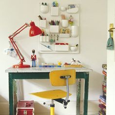 a yellow chair sitting under a desk next to a lamp