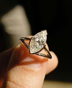 a person holding a ring with a diamond in it's center and an arrow on the side