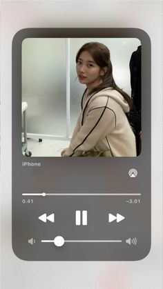 an iphone screen with the image of a woman in headphones and music playing on it