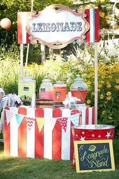 an outdoor lemonade stand is set up in the grass