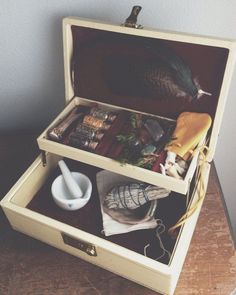 an open suitcase filled with items on top of a wooden table