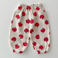 a pair of pants with apples printed on the bottoms and bottom, sitting on a white surface